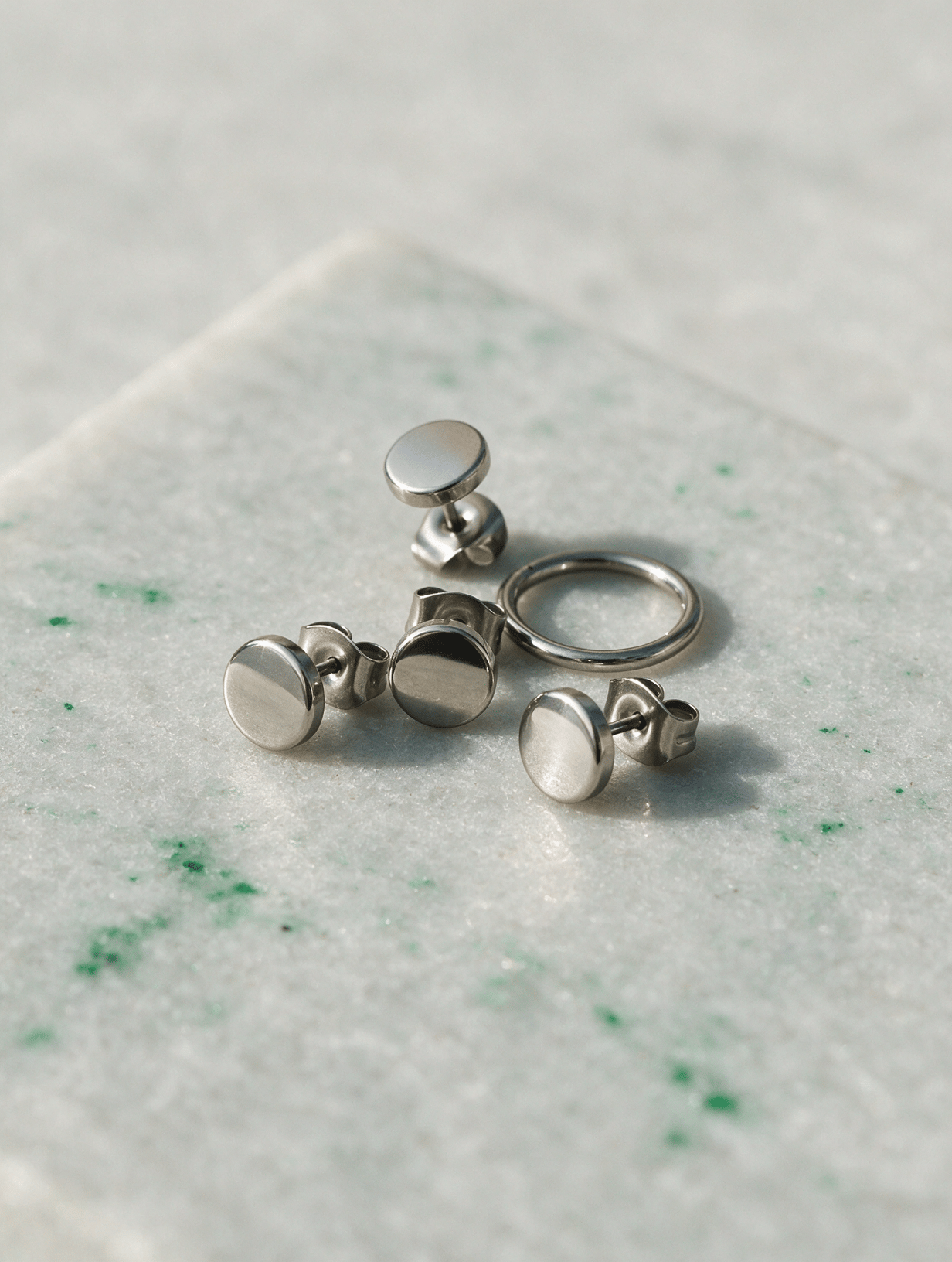 Polished titanium jewellery studs and a hoop