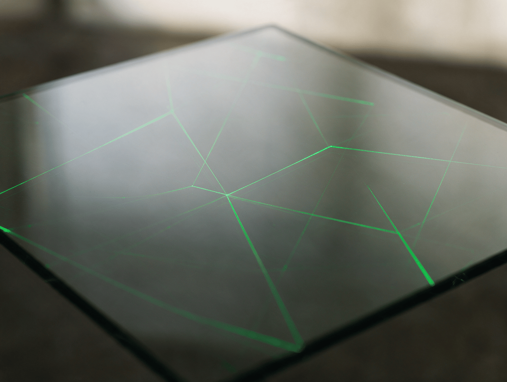 Fine green laser light lines on dark glass