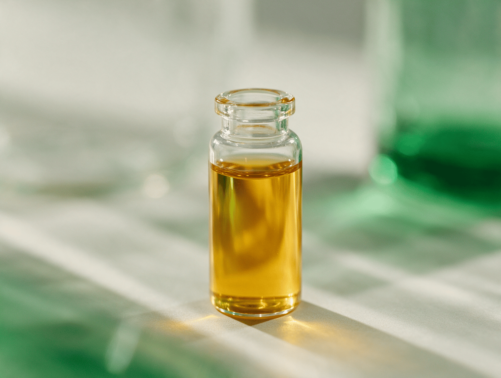 Amber golden liquid in a glass vial against soft light