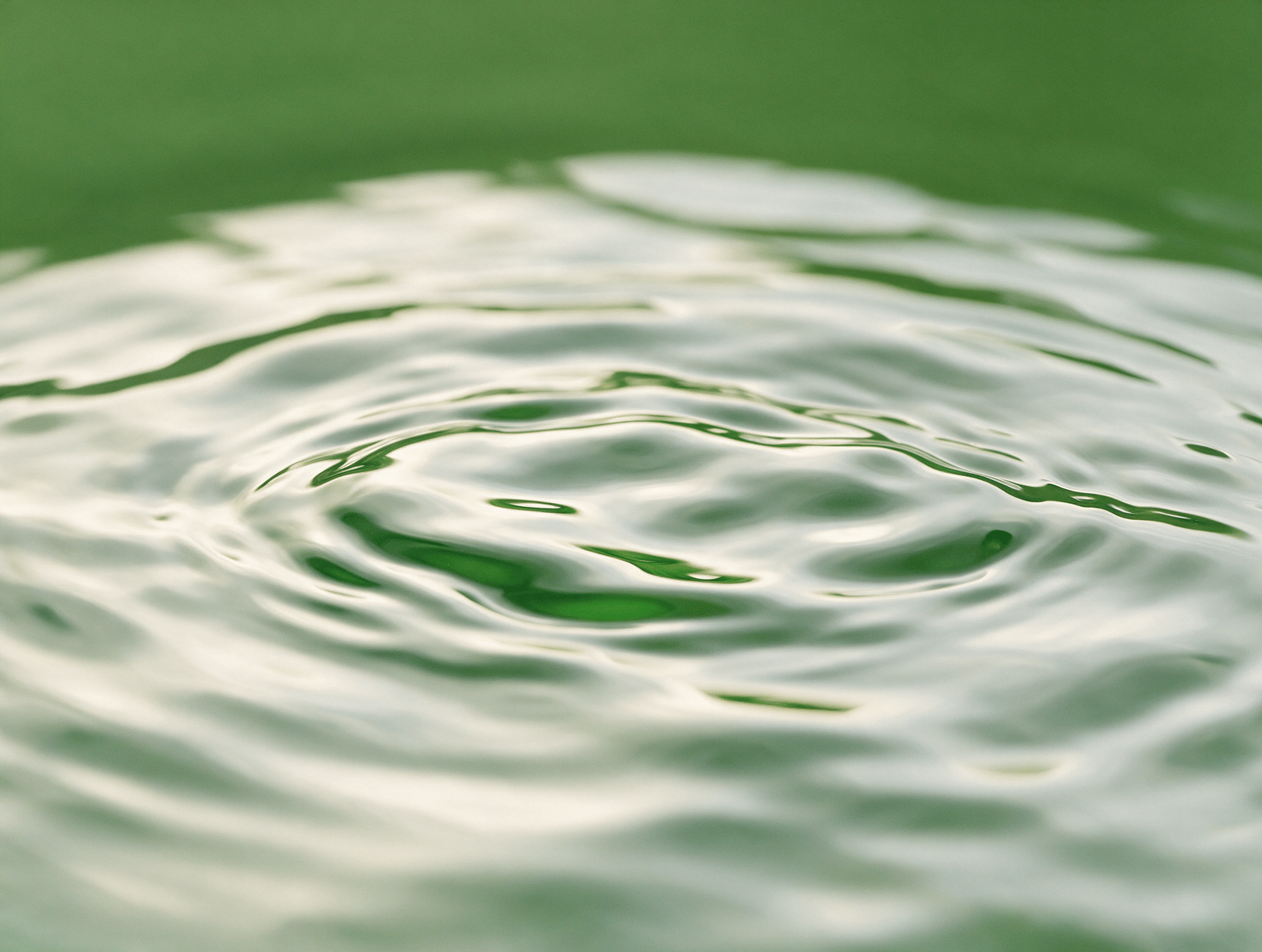 Smooth ripples on water in soft green light
