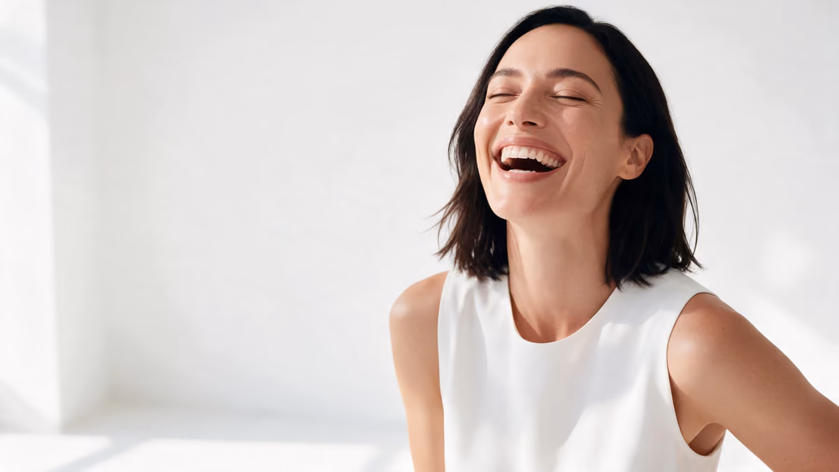 Smiling woman laughing in bright natural light