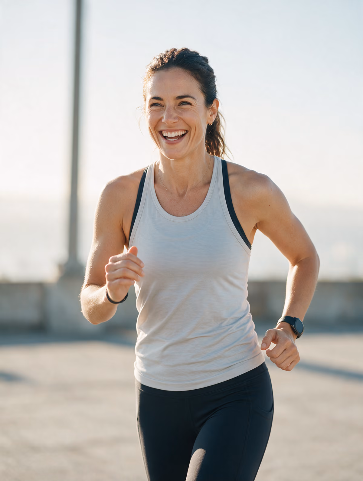 Smiling woman in activewear outdoors in morning light