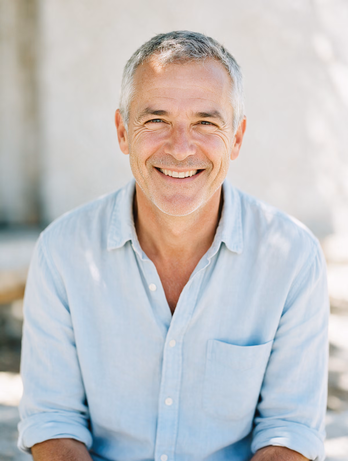 Man with short grey hair and a warm smile